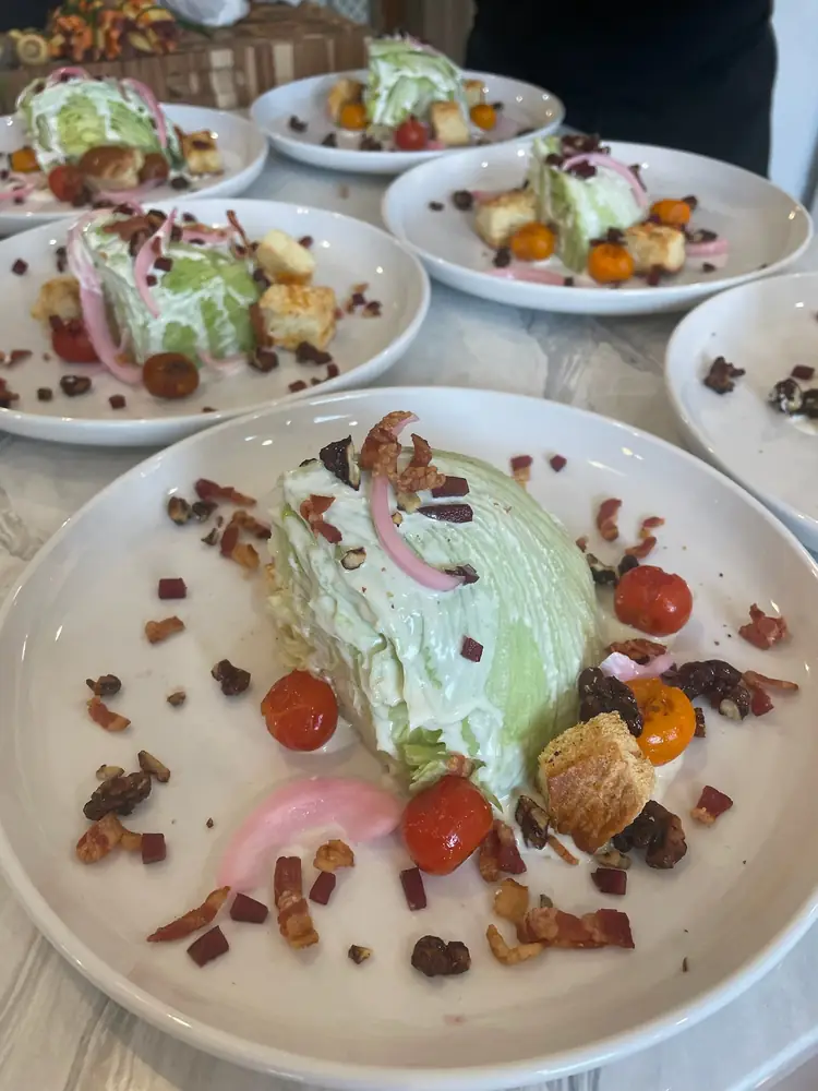 Multiple plated wedge salads prepared consistently for private dinner service.