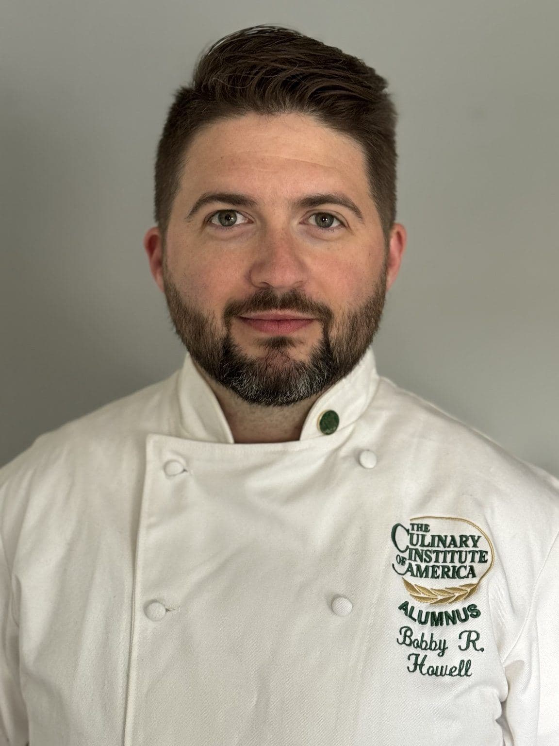 Chef Bobby Howell wearing a Culinary Institute of America chef coat.