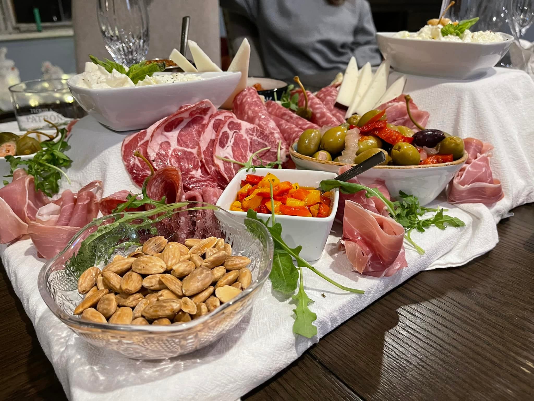 Charcuterie board arranged with meats, cheeses, fruit, and crackers.