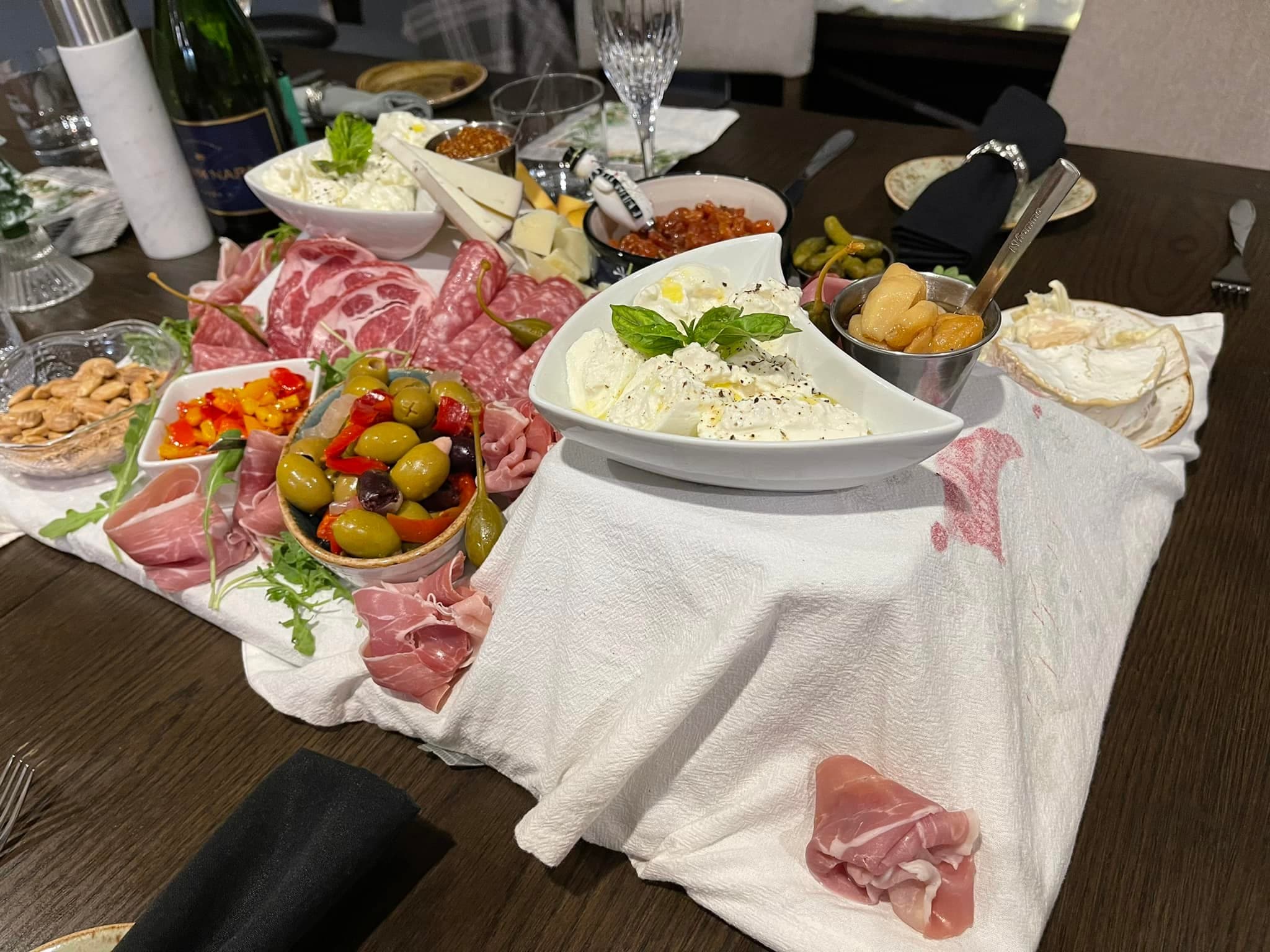 Large charcuterie spread with meats, cheeses, fruit, and accompaniments.