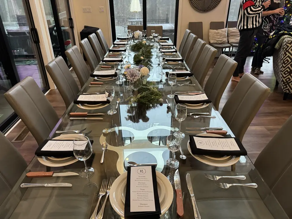 Private dinner table set with glassware, printed menus, napkins, and place settings before guests sit down.